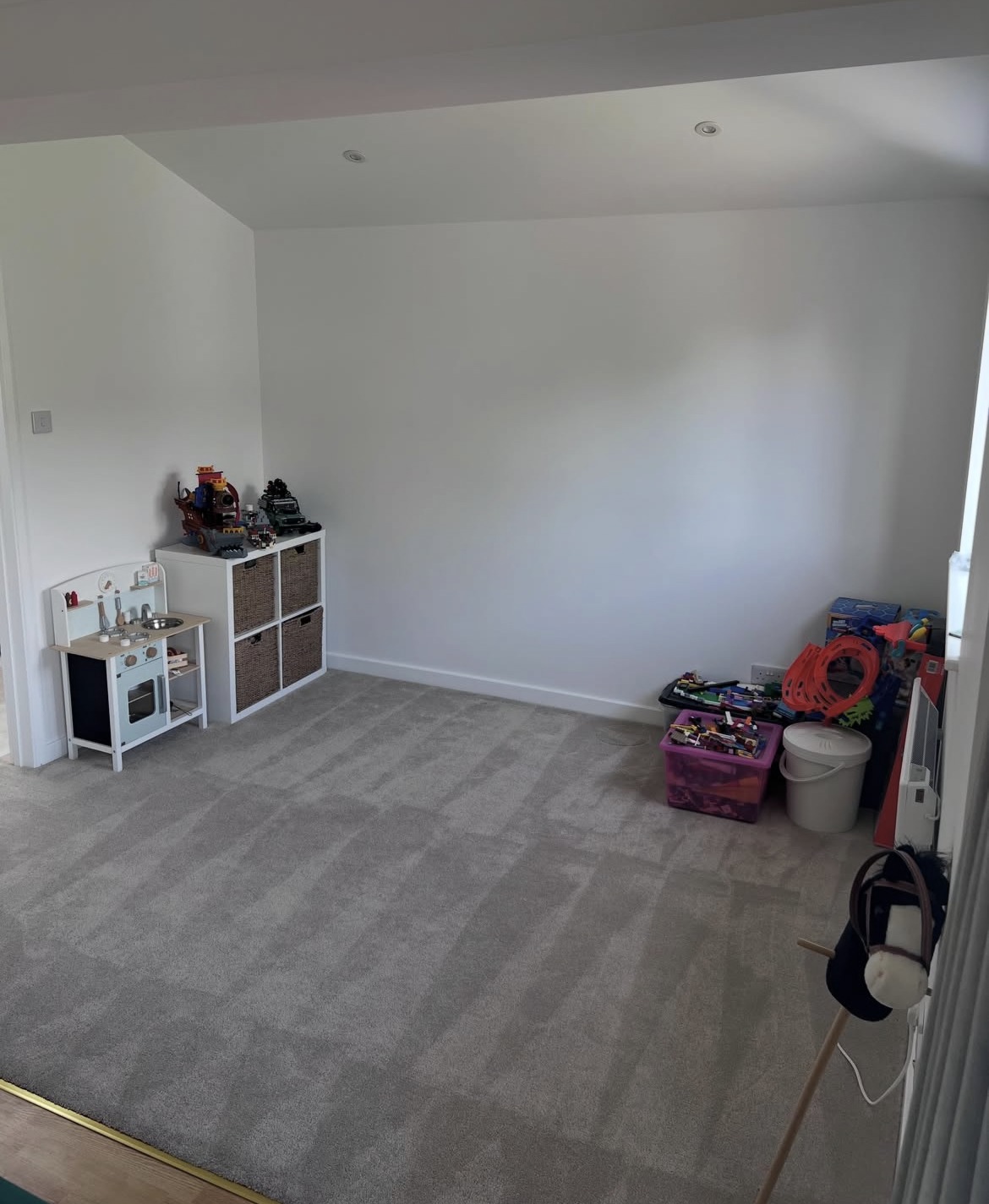 Finished side extension interior with plain plastered walls and new carpet