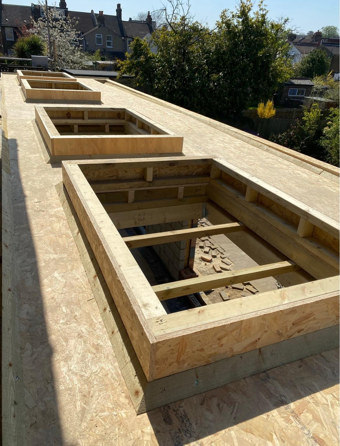 Timber roof structure with rooflight openings during extension construction