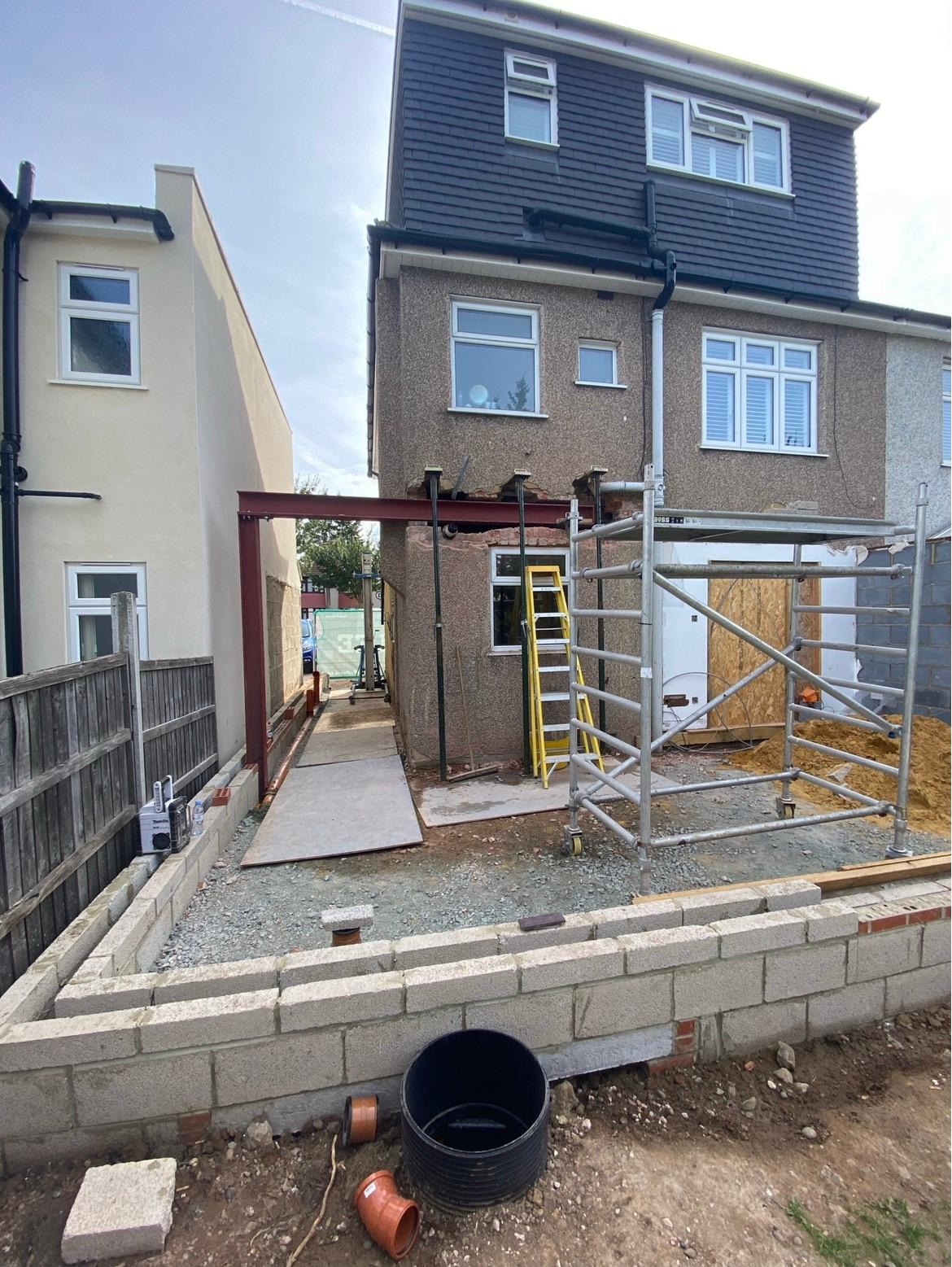 Rear house extension during construction, showing scaffolding, structural steel and foundations