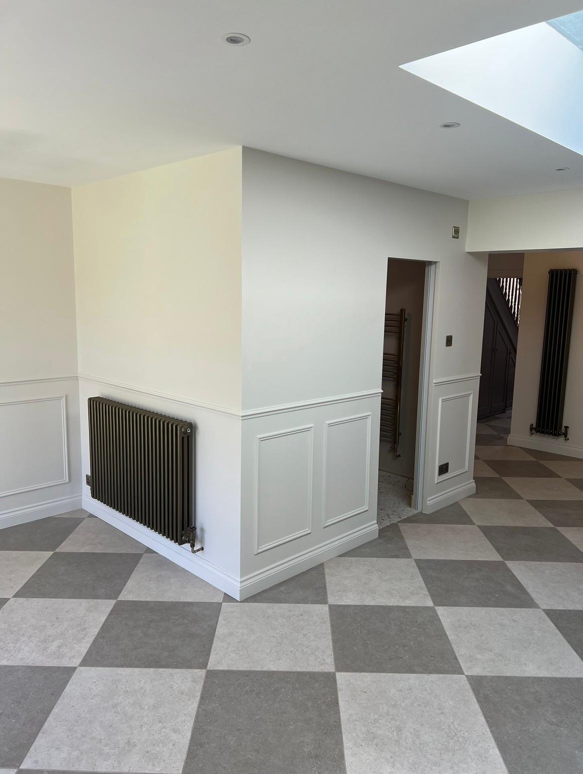 Hallway with decorative panelling, rooflight and tiled flooring after internal alterations