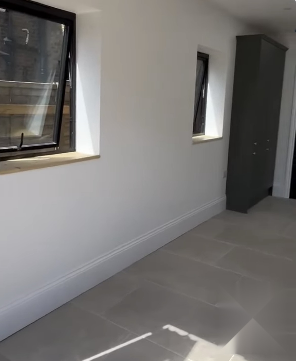 Refurbished room with new windows, skirting and large format floor tiles