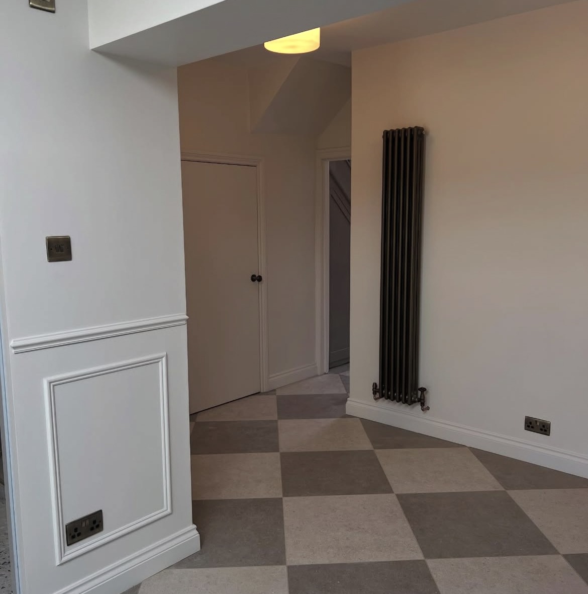 Panelled extension hallway with doors and chequerboard tiled flooring