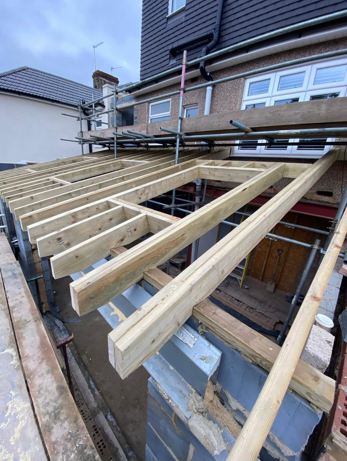 Rear extension in progress with timber joists, scaffolding and steelwork