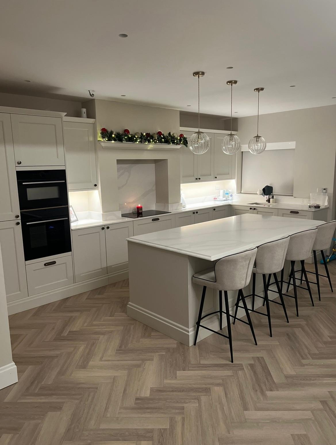 Refurbished kitchen with large island, pendant lighting and herringbone flooring