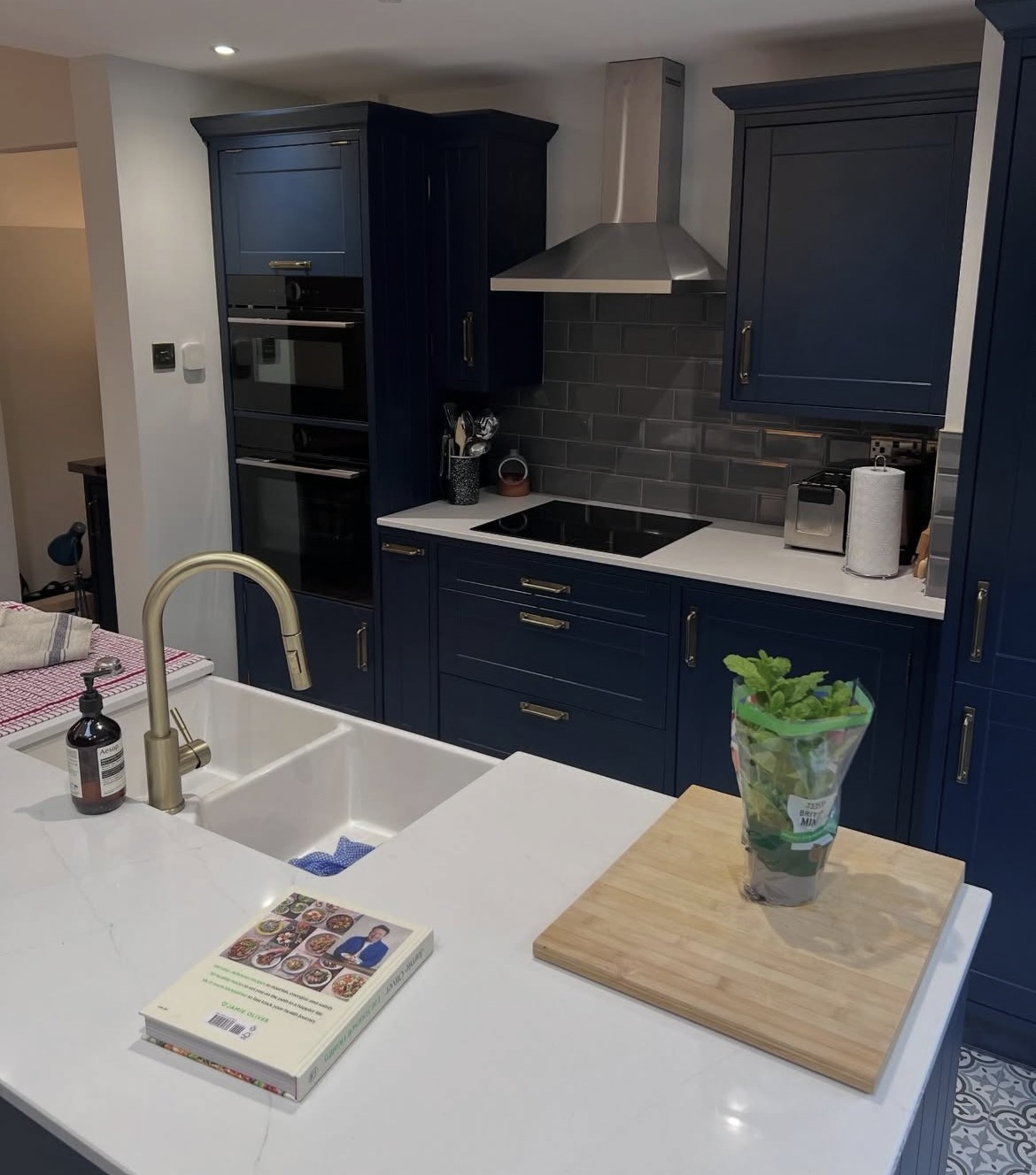 Renovated kitchen with dark blue cabinetry, island and integrated appliances