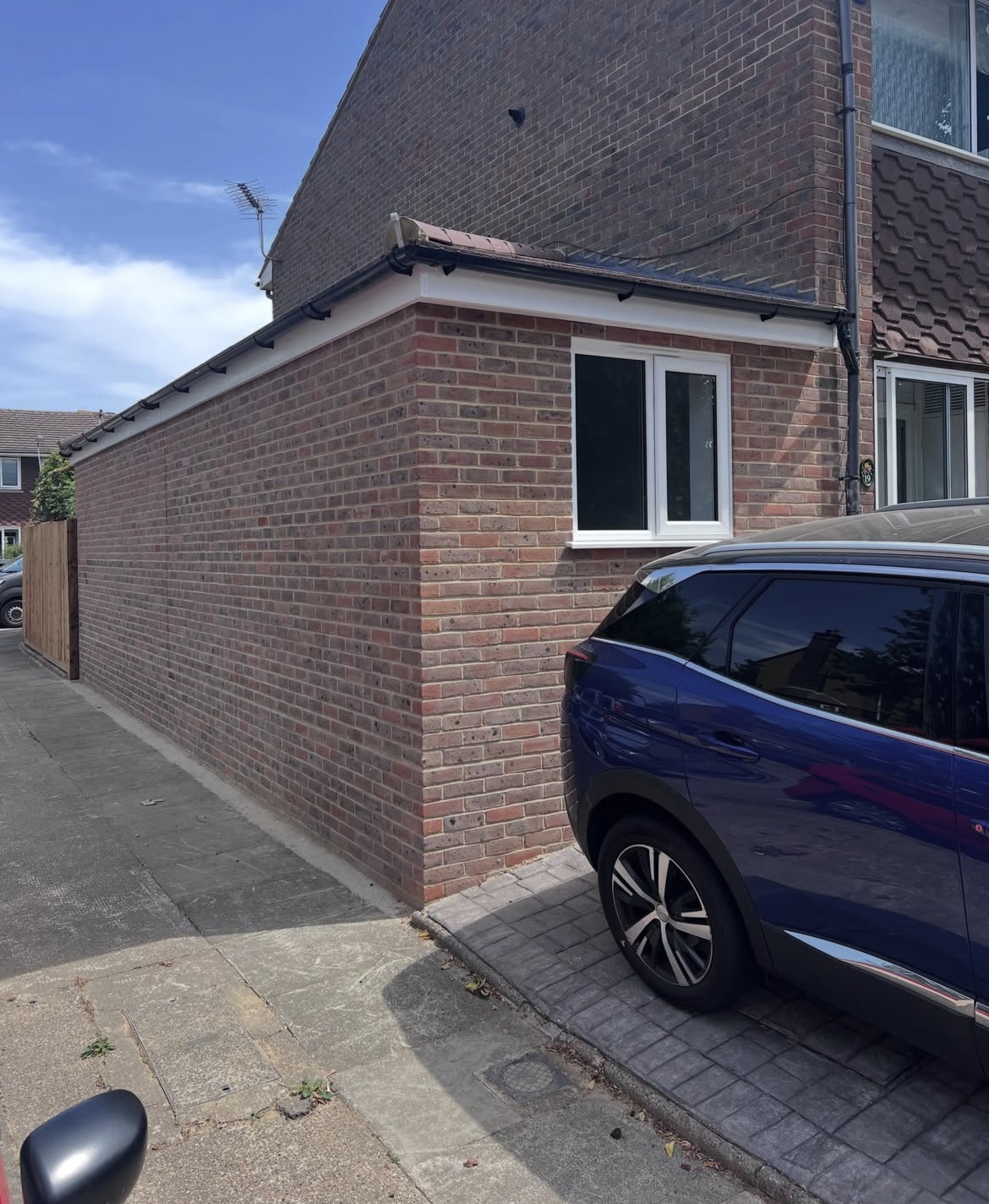 Long brick side extension with tiled roof and white-framed window