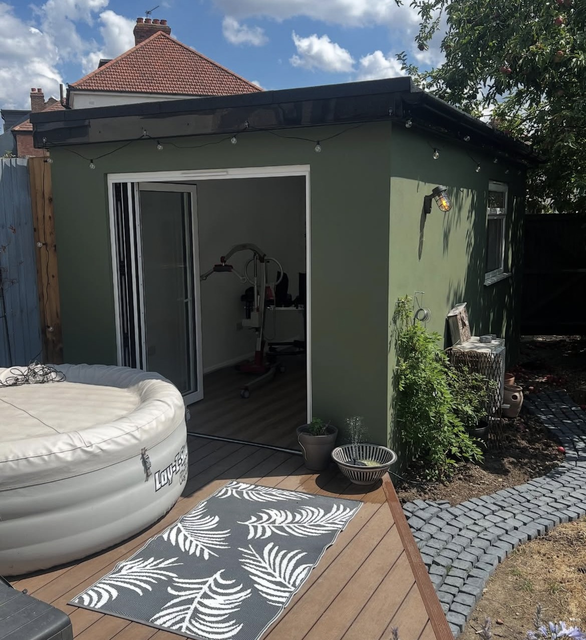 Completed insulated garden outbuilding in Greenwich with bifold doors and decking