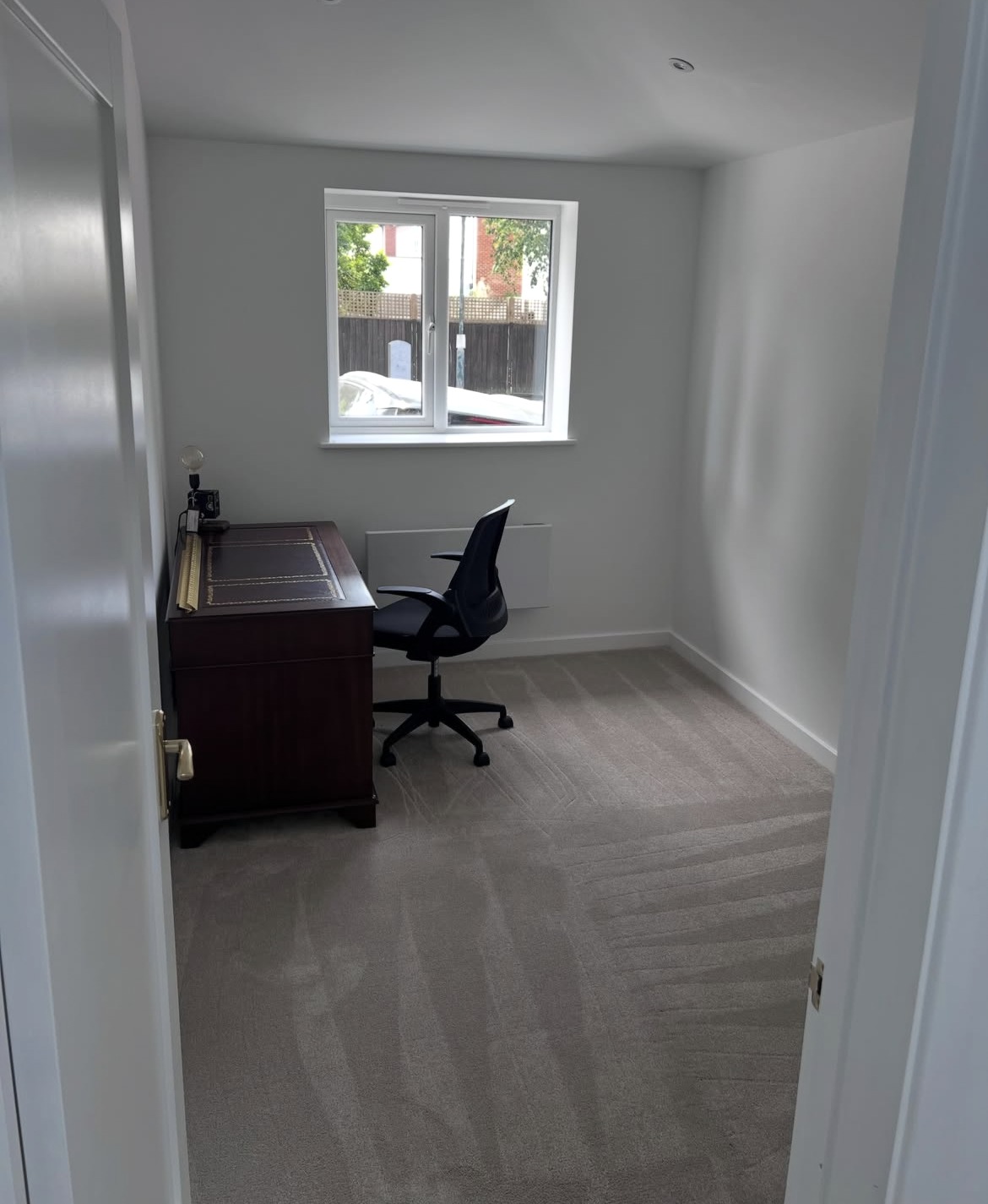 Completed side extension room used as a home office, with new window and carpet