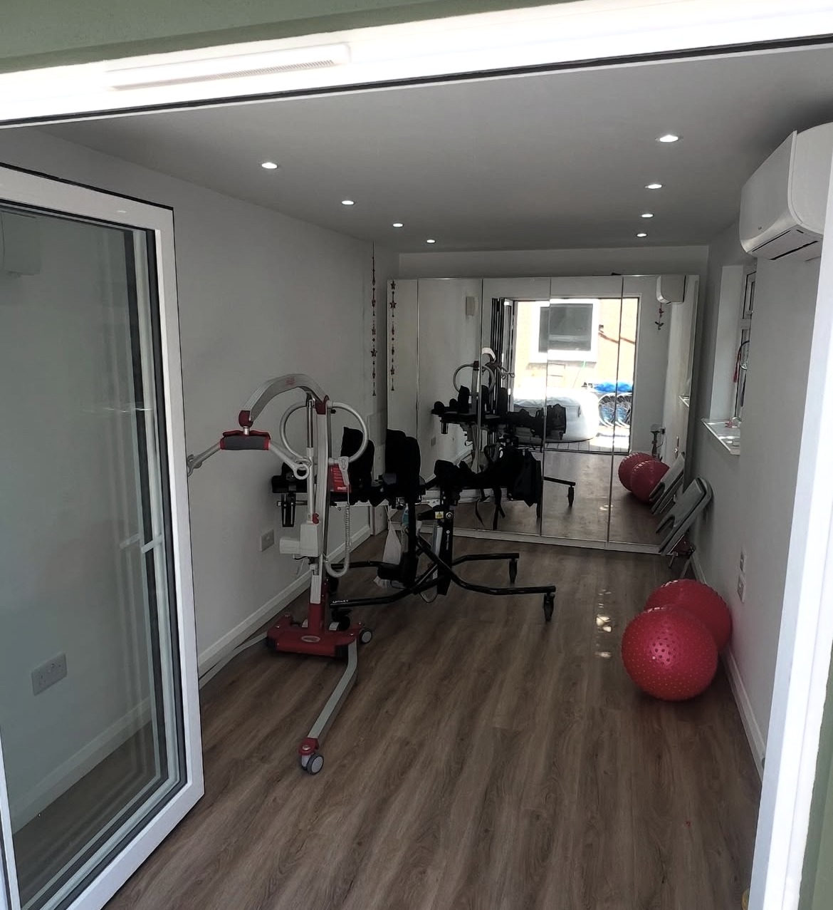 Interior of a finished garden outbuilding with wood-effect flooring and lighting