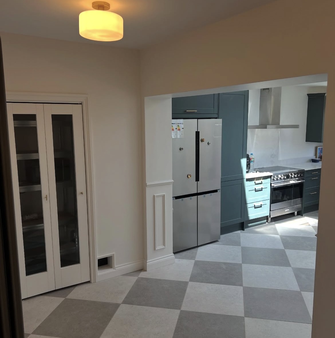 Kitchen fitted within a new rear extension, with dark cabinetry and a range cooker