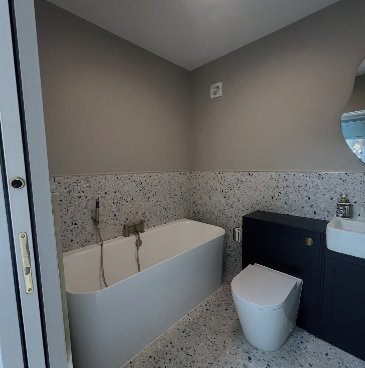 New bathroom built as part of a rear extension, with terrazzo-style tiling and a freestanding bath