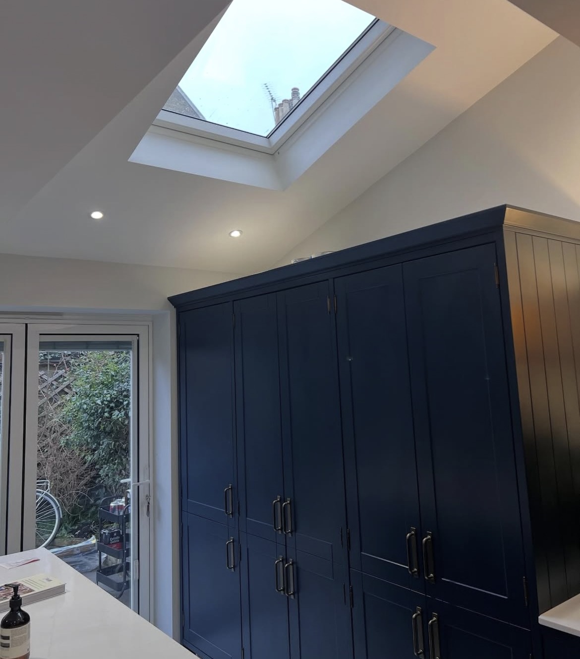 Renovated kitchen beneath a rooflight with garden doors