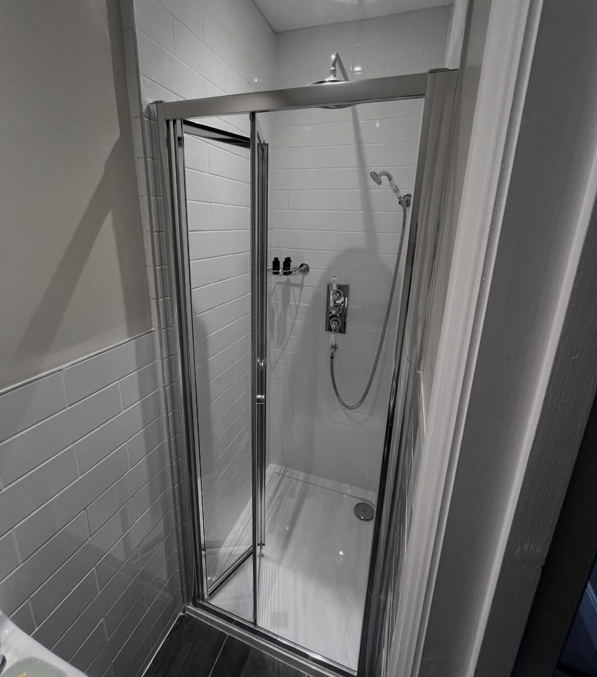 Tiled shower enclosure with chrome fittings in a renovated bathroom