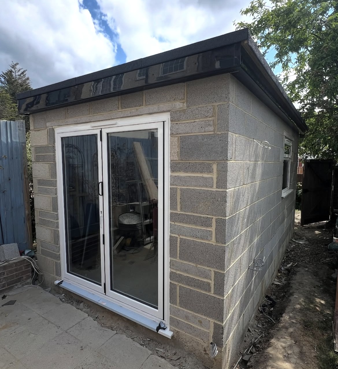 Garden outbuilding during construction with blockwork walls and new doors