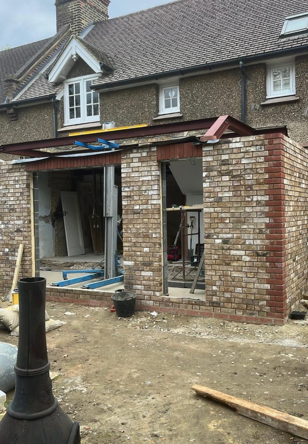 Extension under construction with exposed brickwork and structural steel beams
