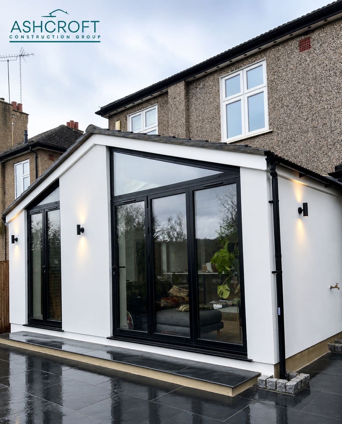 Rendered rear extension with rooflights and dark-framed glazing, branded Ashcroft Construction Group