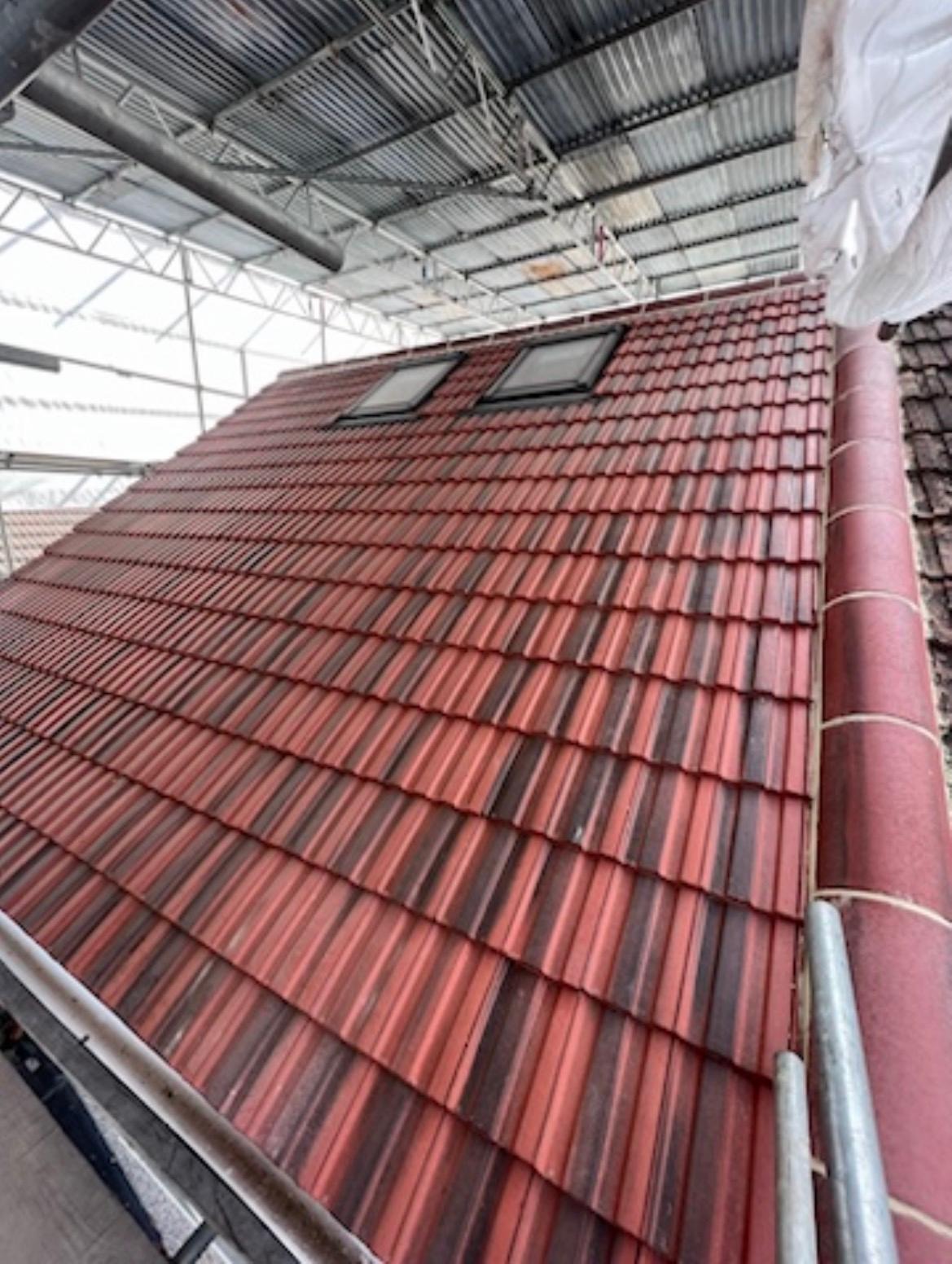 Newly tiled pitched roof with rooflights during roofing works
